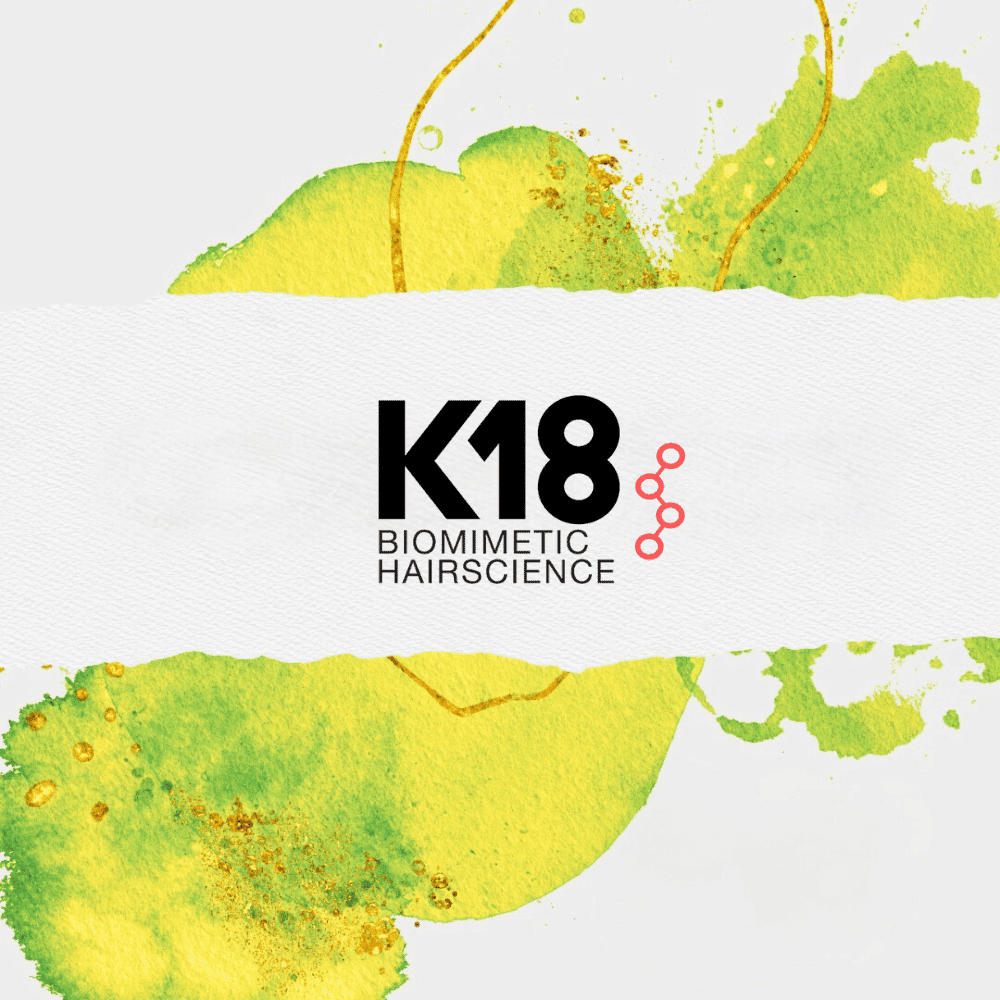 K18 Biomimetic Hairscience logo on a vibrant abstract yellow and green background.